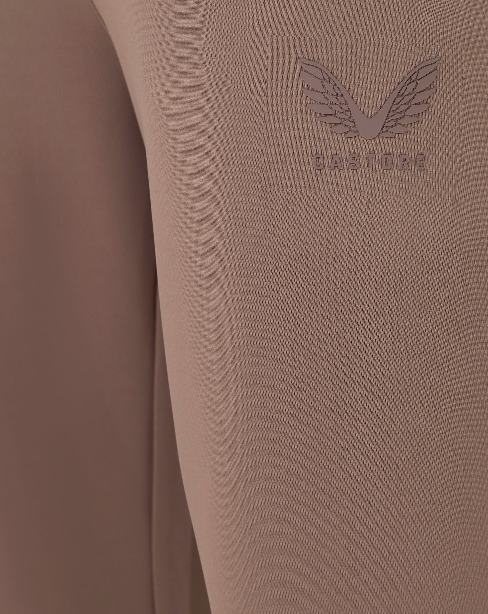Brown fabric with 'Castore' logo on a matching brown background