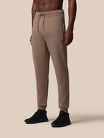 Beige jogger pants worn by a person on a beige background