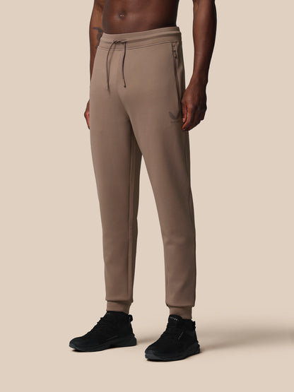 Beige jogger pants worn by a person on a beige background
