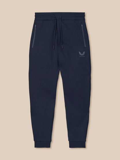 Navy blue jogger pants with a brand logo on a beige background