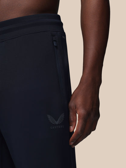 Black athletic pants with a logo on a beige background