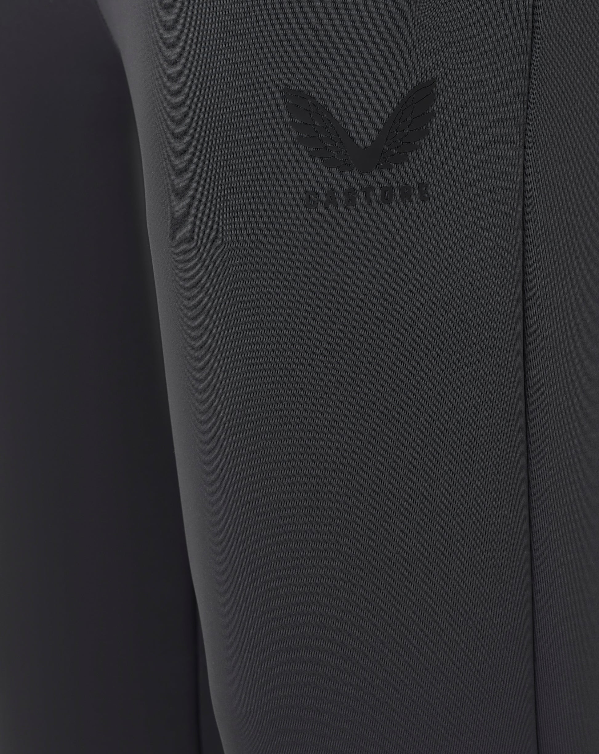 Close-up of a dark gray garment with a brand logo on a plain background