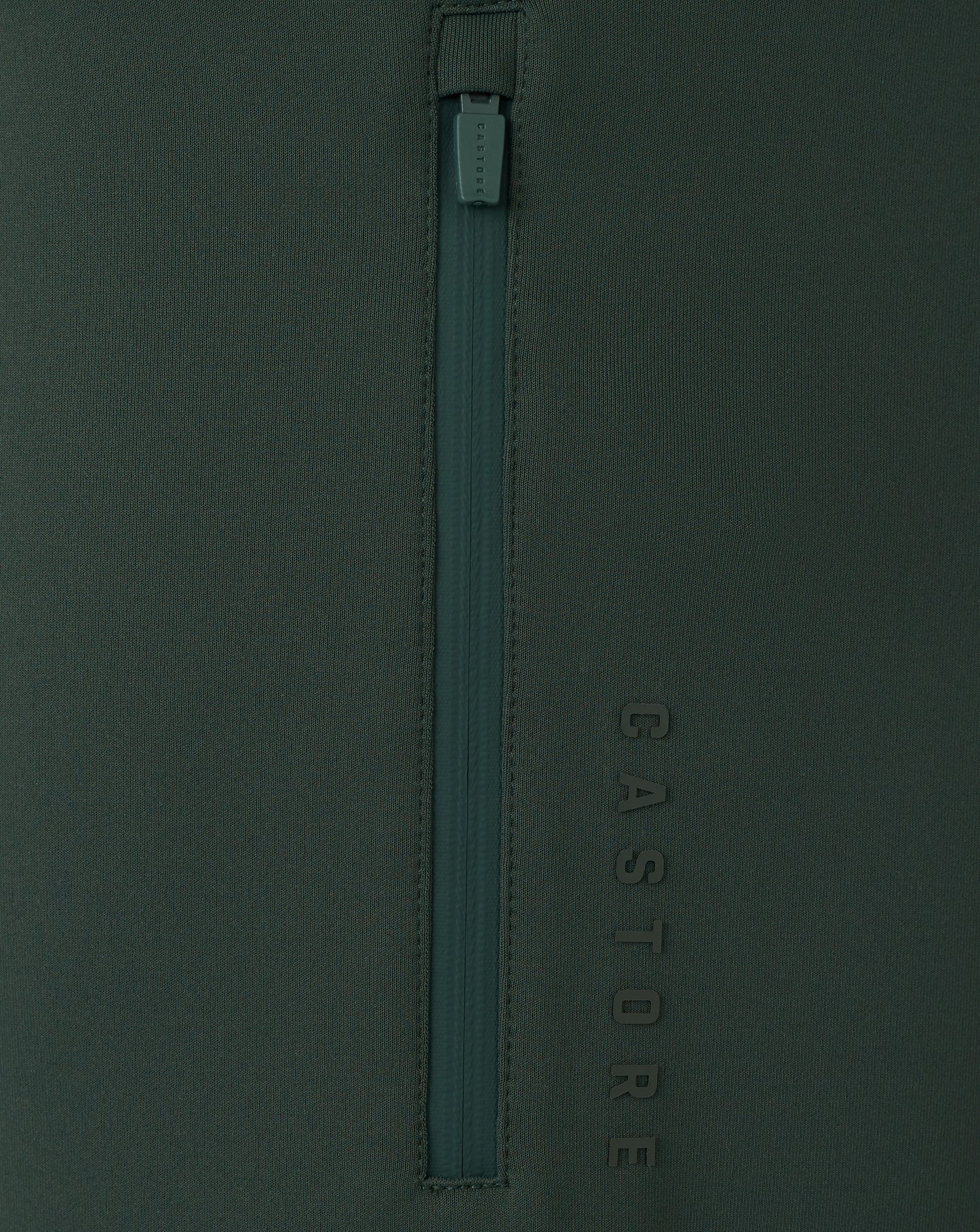 Dark green zipper on a dark green background with 'Castore' branding.