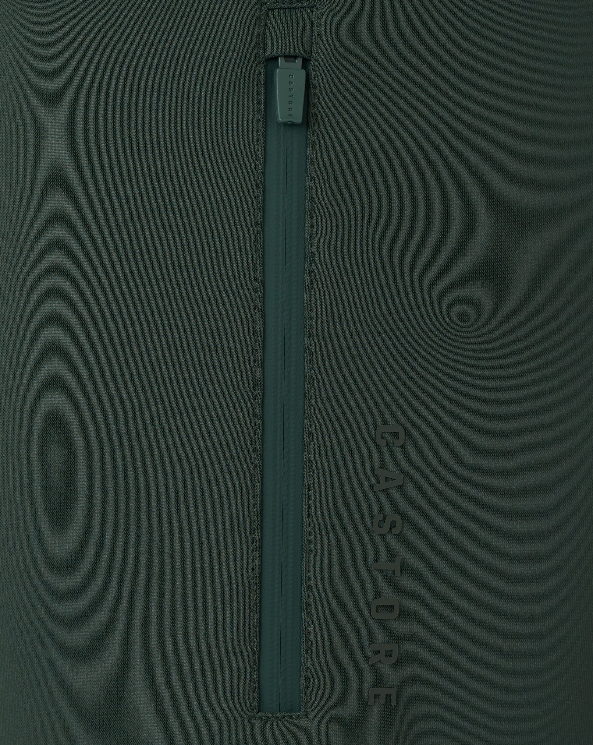 Dark green zipper on a dark green background with 'Castore' branding.