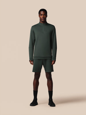 Man wearing a green athletic outfit on a beige background