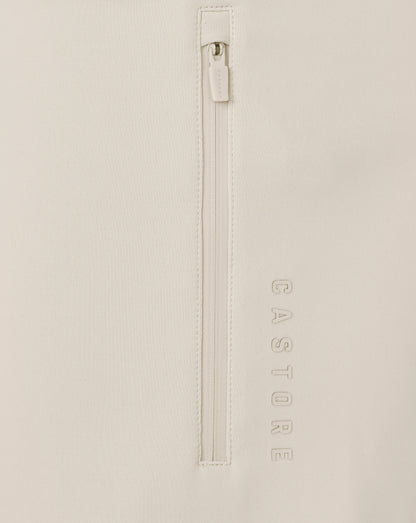 Close-up of a beige jacket with a zipper and 'CASTORE' branding.