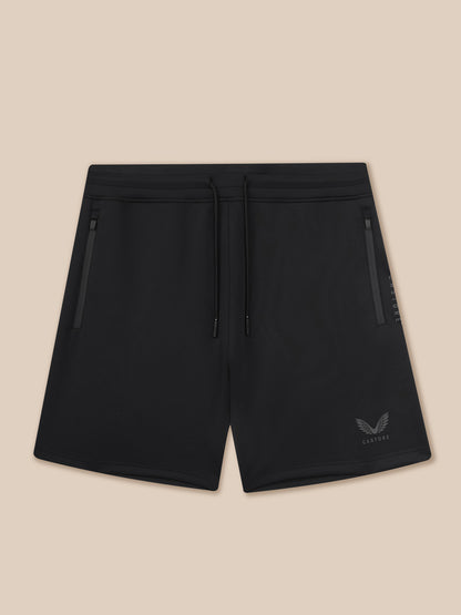 Black shorts with a brand logo on a beige background
