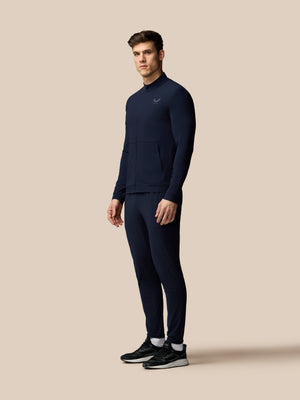 Man wearing a navy tracksuit on a beige background