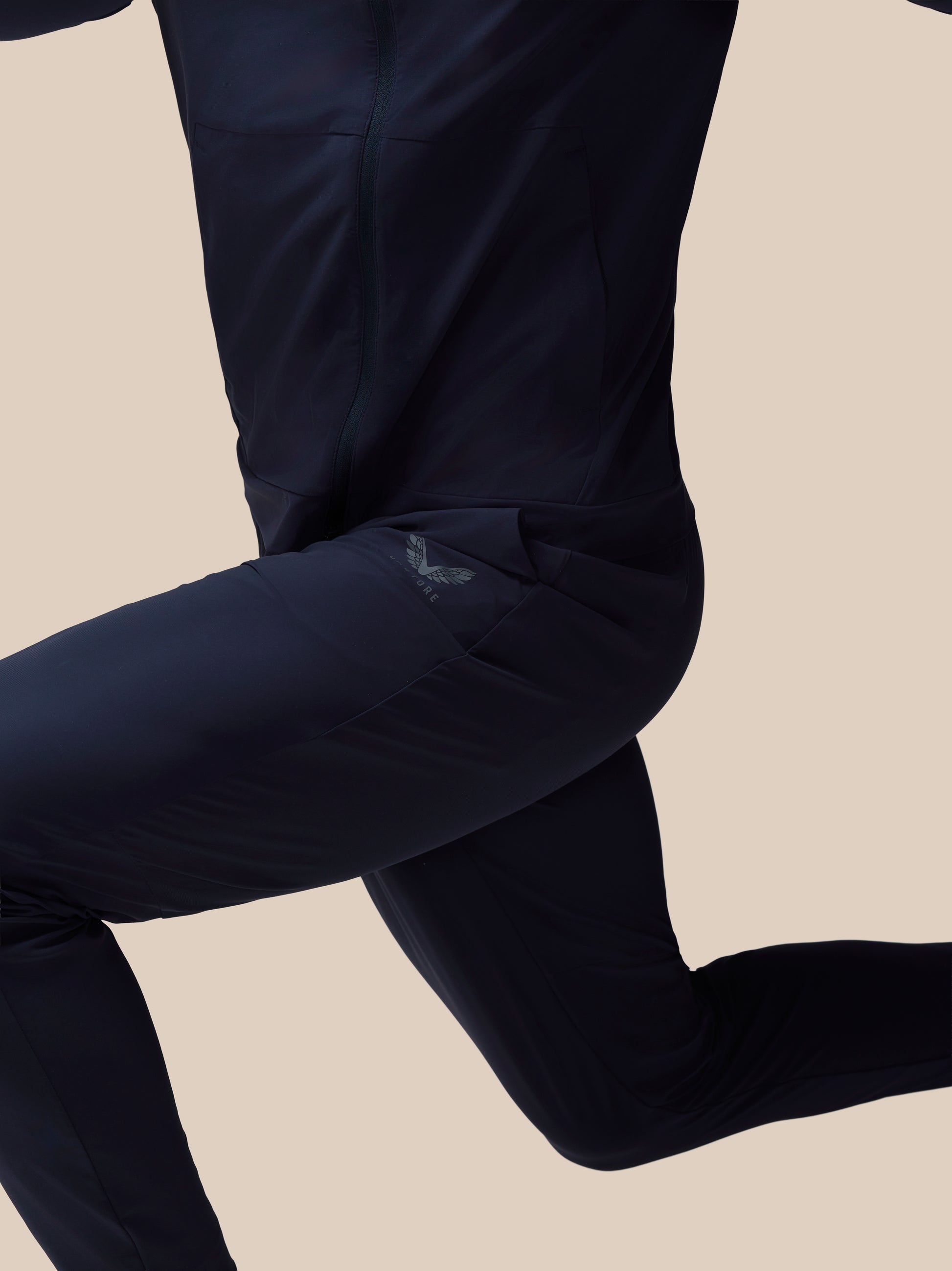 Person wearing black leggings on a beige background