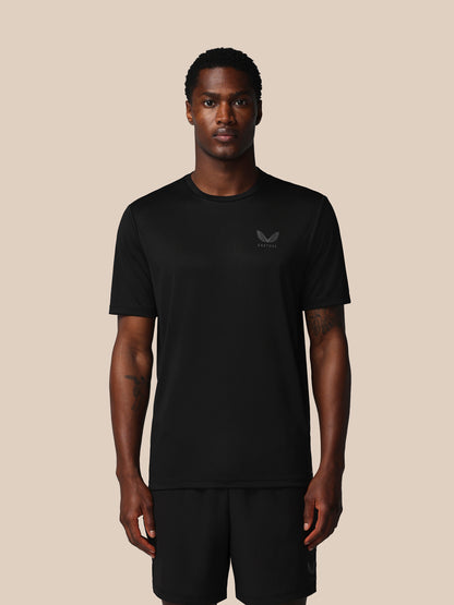 Man wearing a black t-shirt with a logo on a beige background