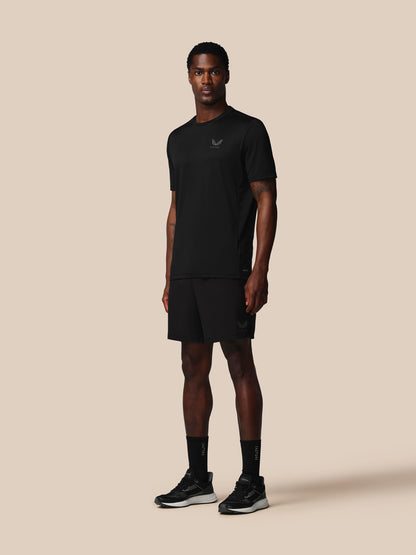 Man wearing a black t-shirt and shorts set on a beige background