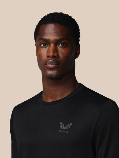 Man wearing a black sweatshirt with a logo on a beige background