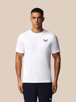 Man wearing a white t-shirt with a logo on a beige background