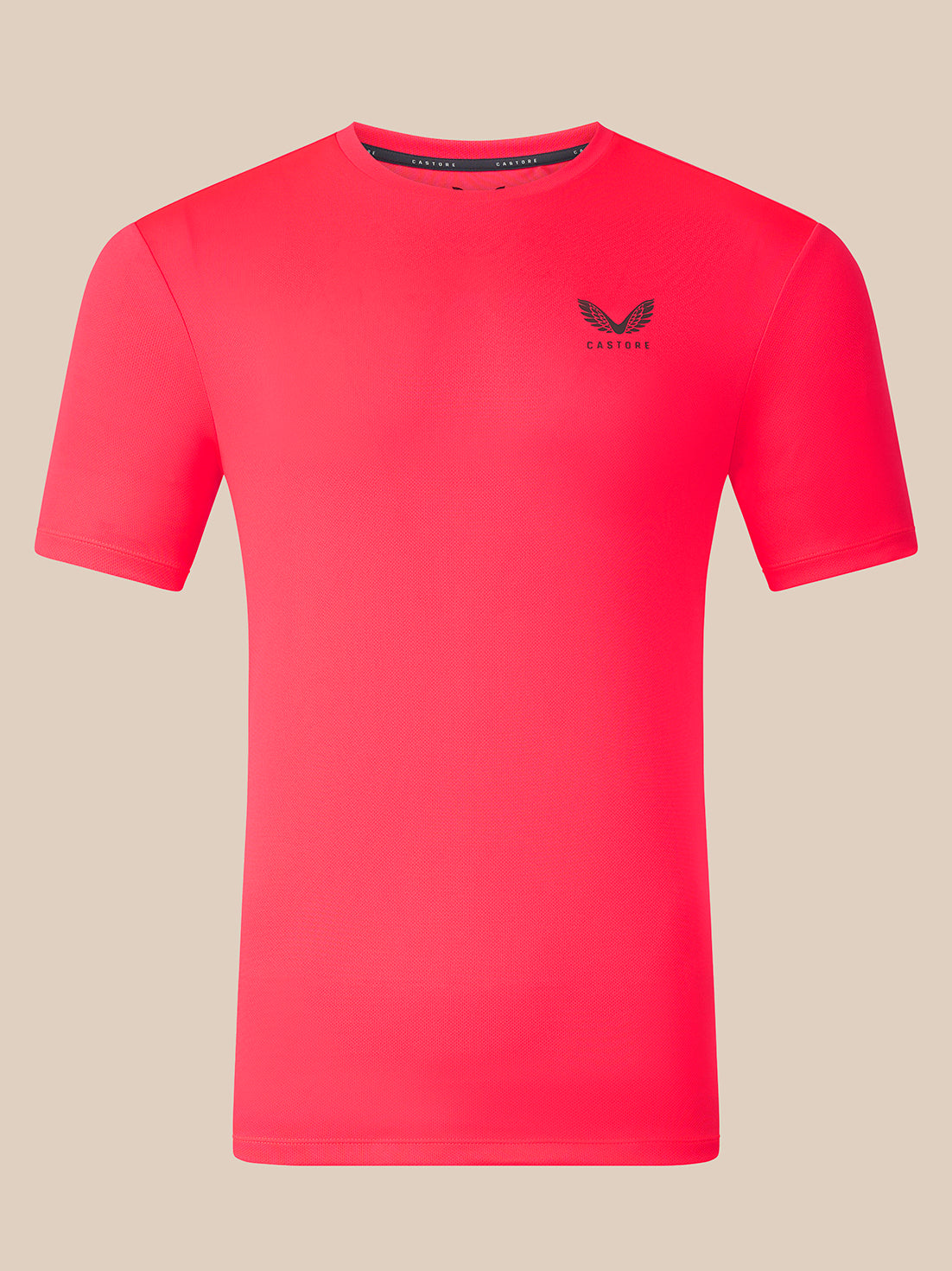 A bright pink short-sleeve athletic t-shirt with a small black winged logo and the brand name 'CASTORE' printed on the left chest, displayed on a solid beige background.