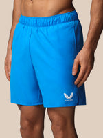 Blue athletic shorts with a brand logo on a beige background