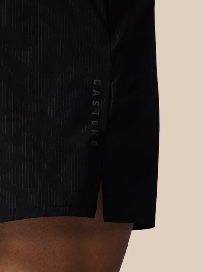 Black athletic shorts with 'CASTORE' branding on a beige background