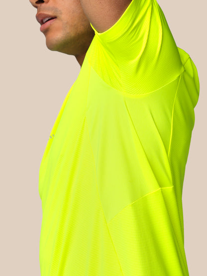 Neon yellow long-sleeve shirt worn by a person on a beige background