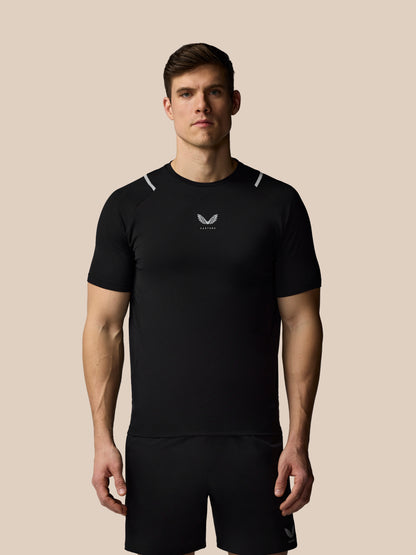 Man wearing a black athletic outfit with a logo on a beige background