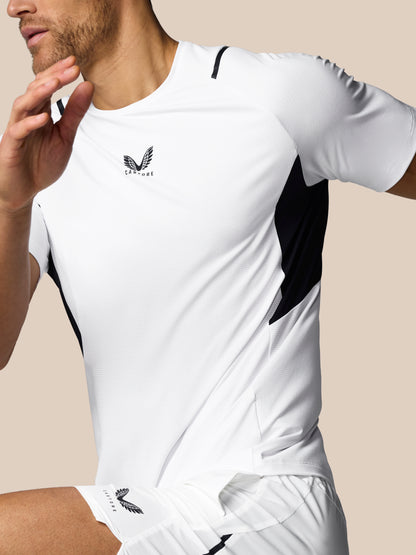 Person wearing a white athletic outfit with black accents on a beige background