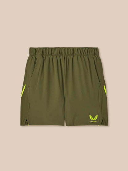 Green athletic shorts with yellow accents on a beige background