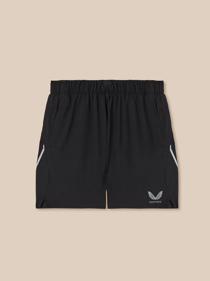 Black athletic shorts with a logo on a beige background