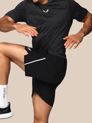 Person wearing black athletic outfit with a visible brand logo on a beige background