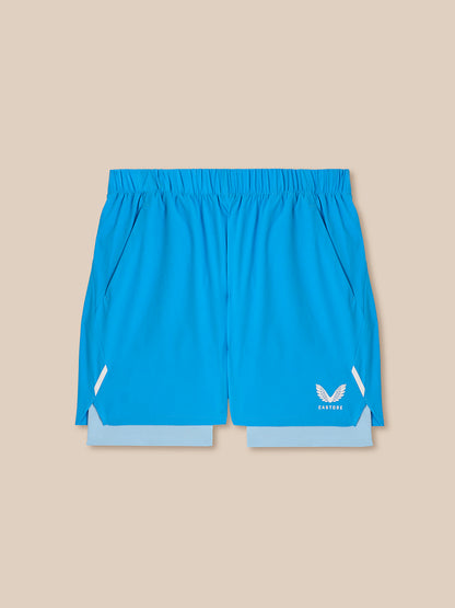 Blue athletic shorts with a logo on a beige background