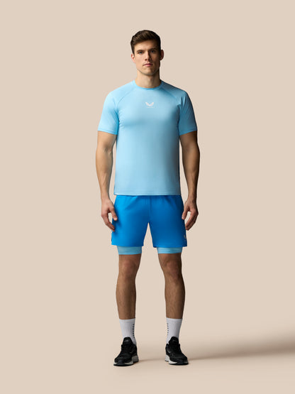 Man wearing a light blue athletic shirt and shorts on a beige background