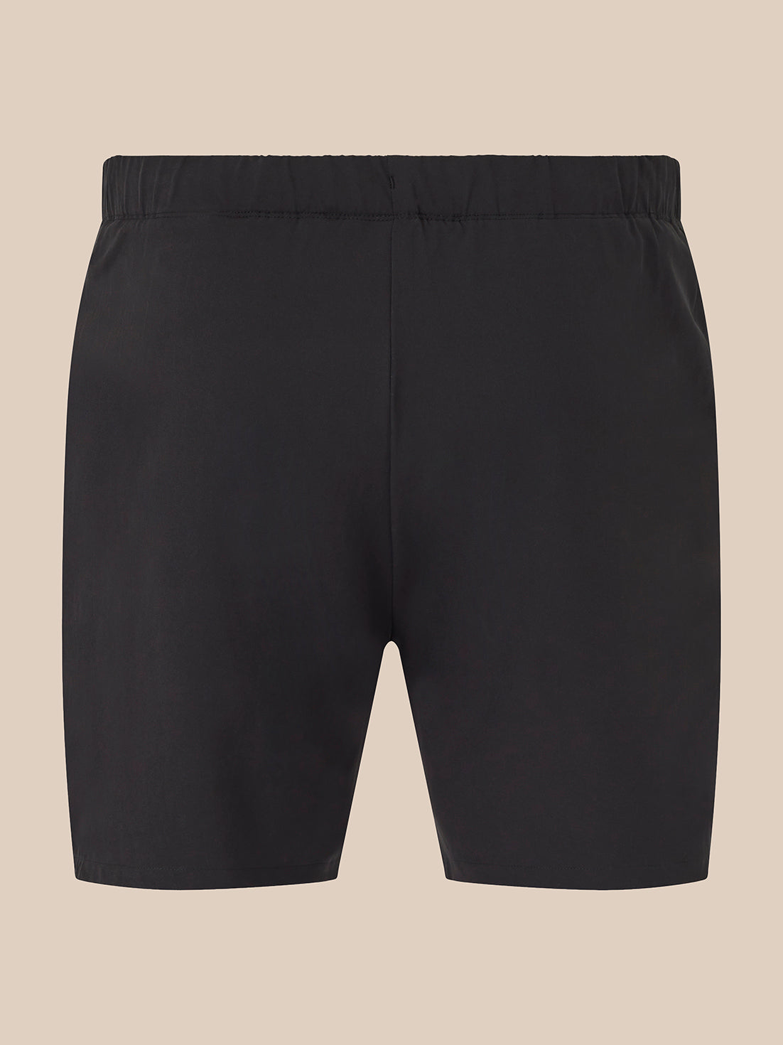 Black athletic shorts with an elastic waistband, shown flat against a solid beige background.
