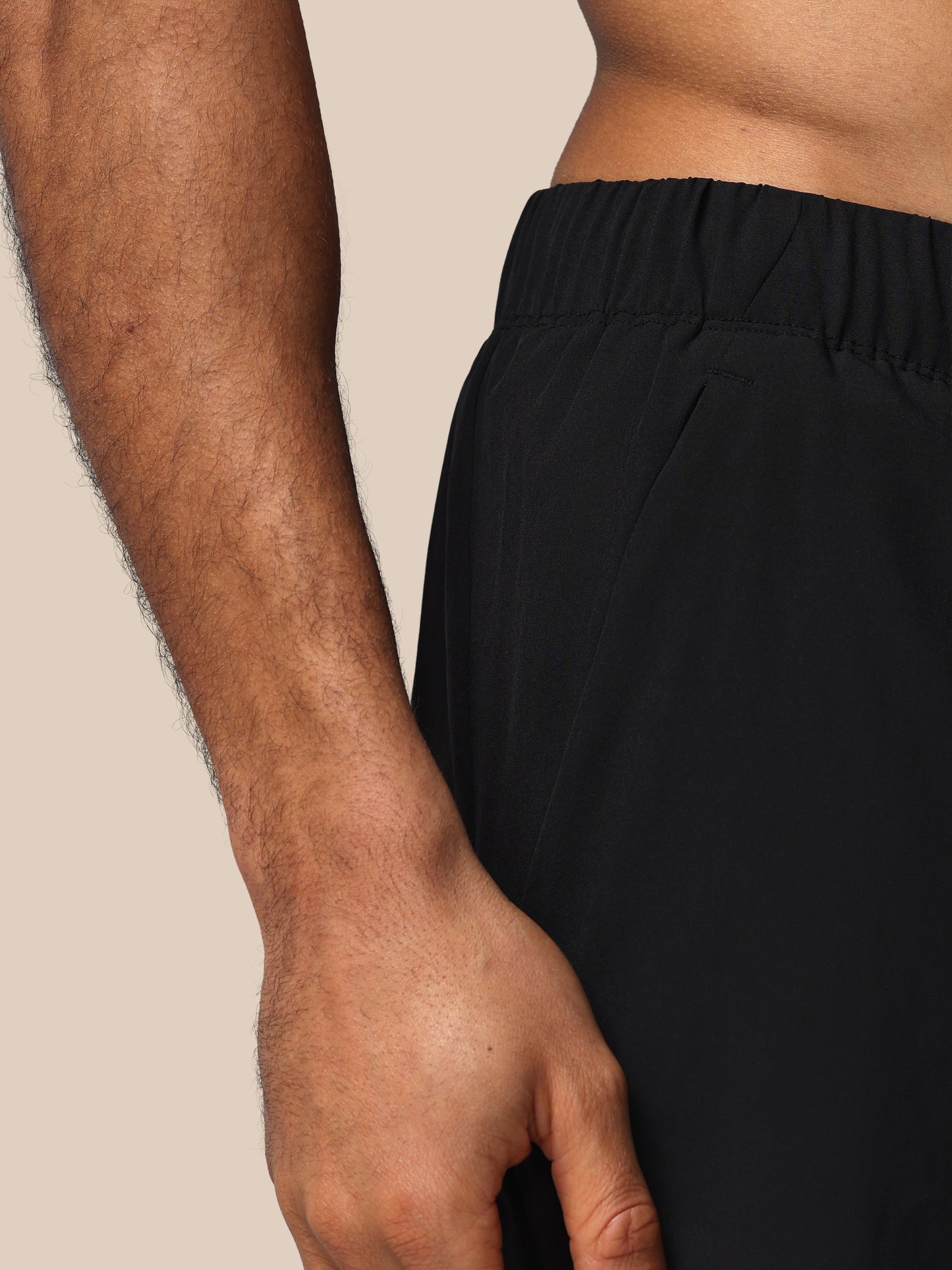 Person wearing black pants with a neutral background