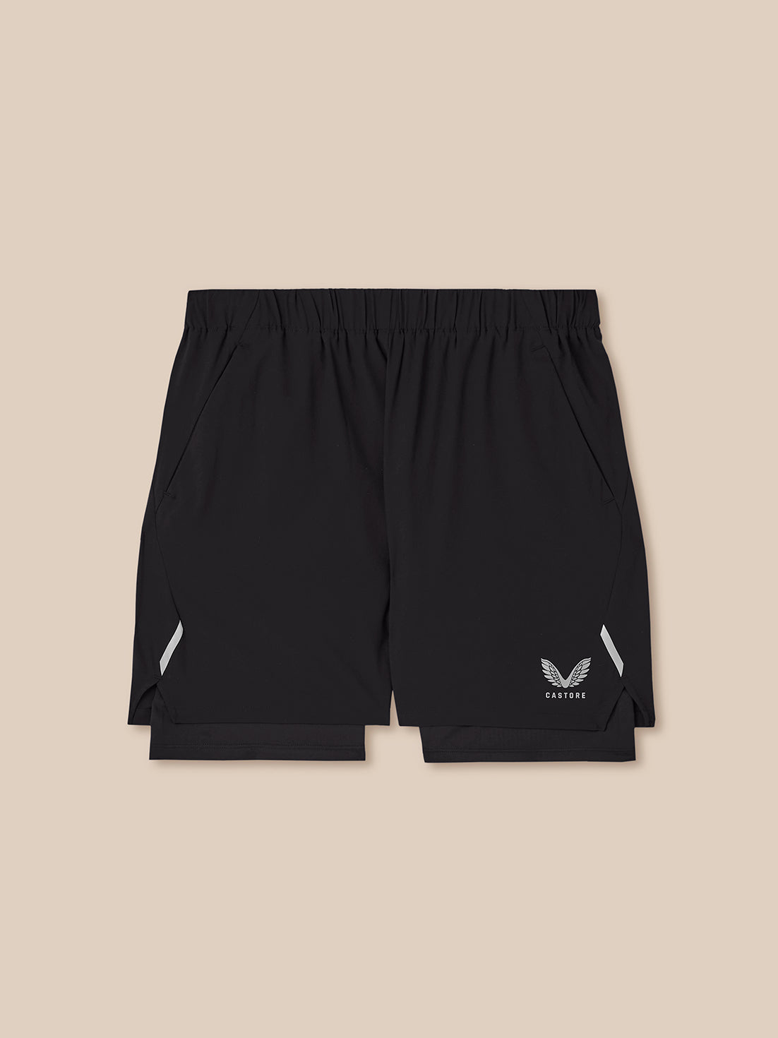 Black athletic shorts with a white wing logo and 'CASTORE' text on the lower left leg, displayed flat against a solid beige background.