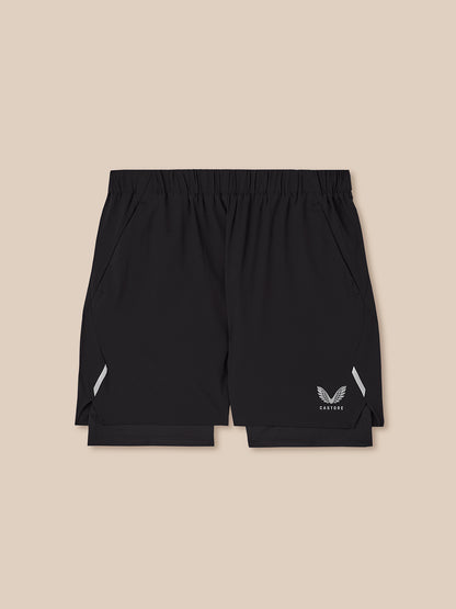 Black athletic shorts with a white wing logo and 'CASTORE' text on the lower left leg, displayed flat against a solid beige background.
