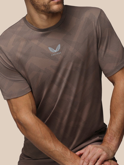 Man wearing a brown athletic t-shirt with a logo on a beige background