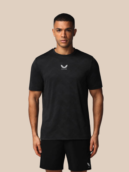 Man wearing a black t-shirt with a logo on a beige background