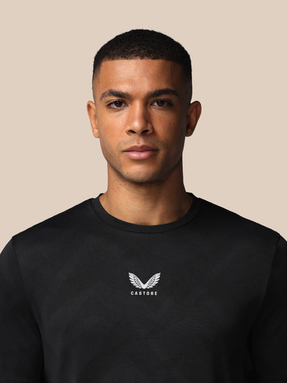 Man wearing a black sweatshirt with a logo on a beige background