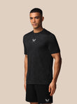 Man wearing a black t-shirt with a logo on a beige background