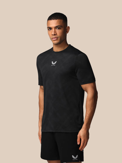 Man wearing a black t-shirt with a logo on a beige background