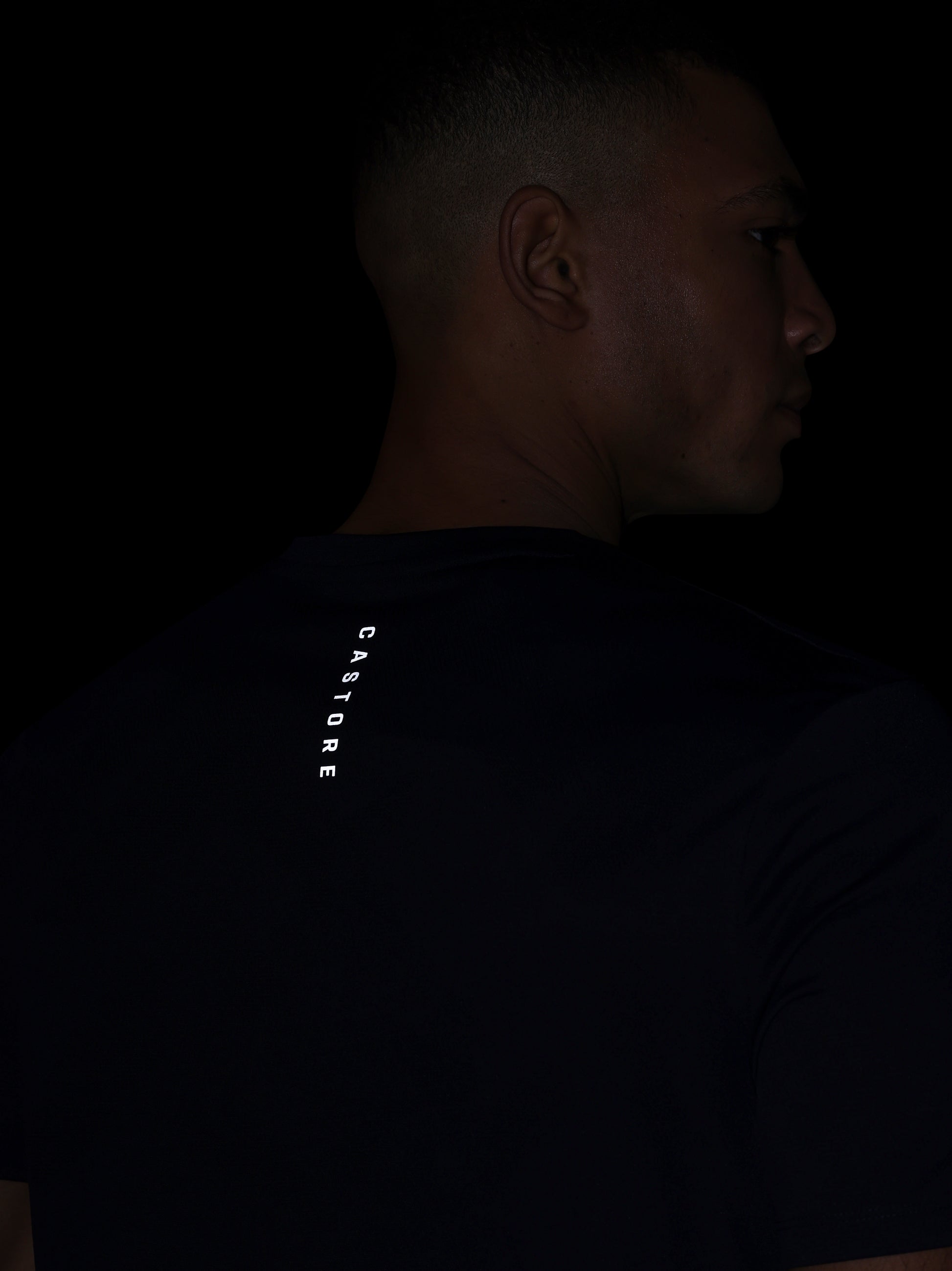 Person wearing a dark shirt with 'CASTORE' branding on the back.