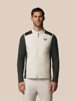 Man wearing a black and white jacket with a visible brand logo on a beige background