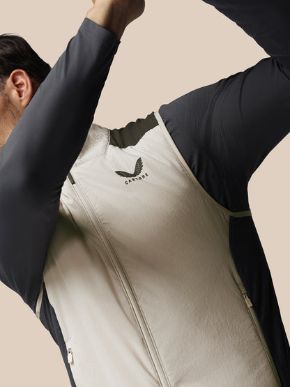 Person wearing a white gilet with a Castore logo on a beige background