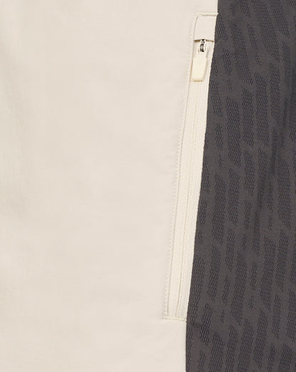Close-up of a beige and black patterned fabric with a zipper detail.