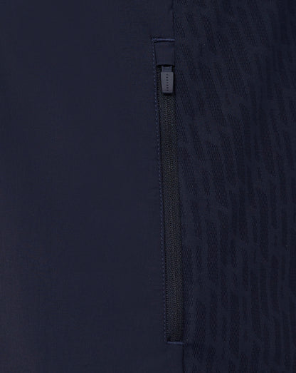 Close-up of a dark blue garment with a zipper detail on a matching background
