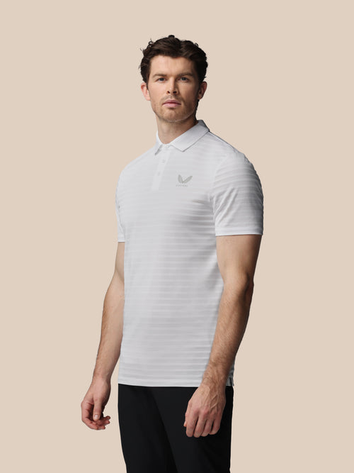 Man wearing a white striped polo shirt on a beige background