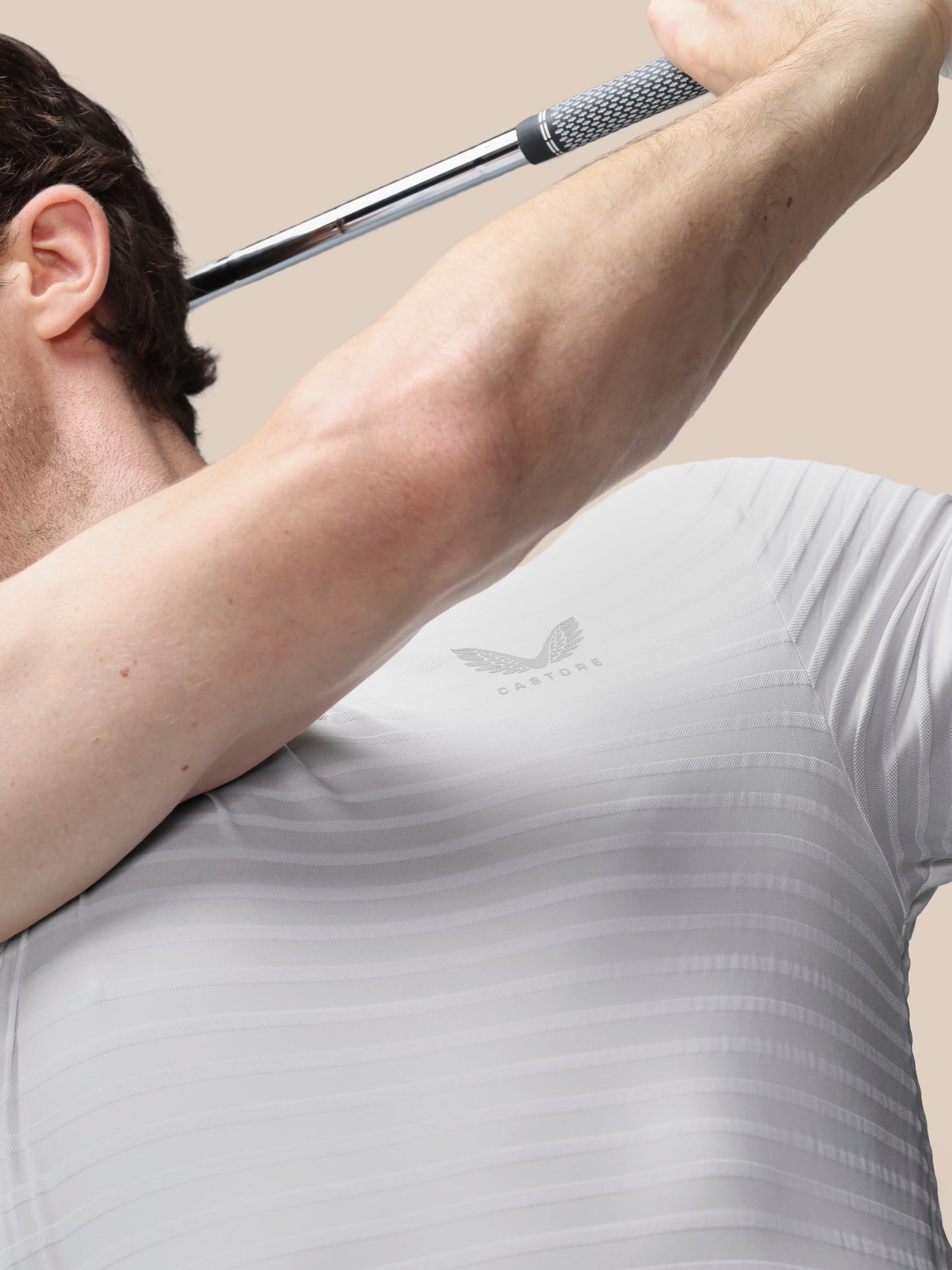 Person in a gray Castore shirt holding a golf club