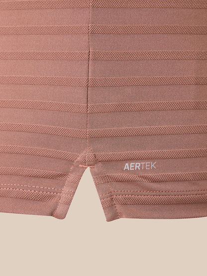 Close-up of ribbed knit athletic shorts in a dusty rose pink color, featuring horizontal compression stripes and a small white AERTEK logo near the hem.