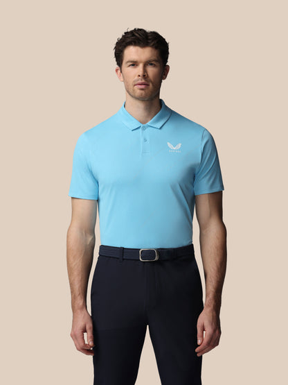 Man wearing a light blue polo shirt with a Castore logo on a beige background