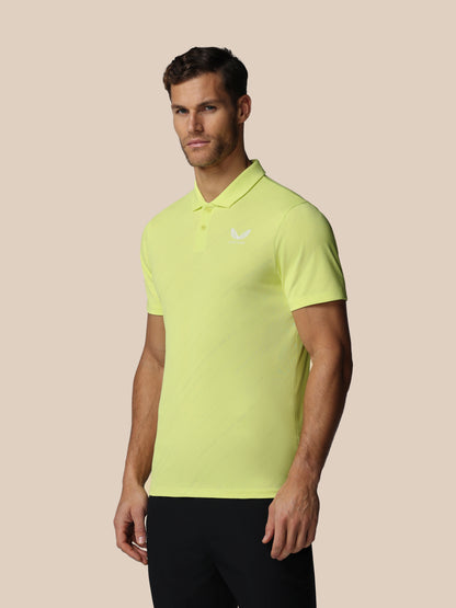 Man wearing a bright yellow polo shirt on a beige background