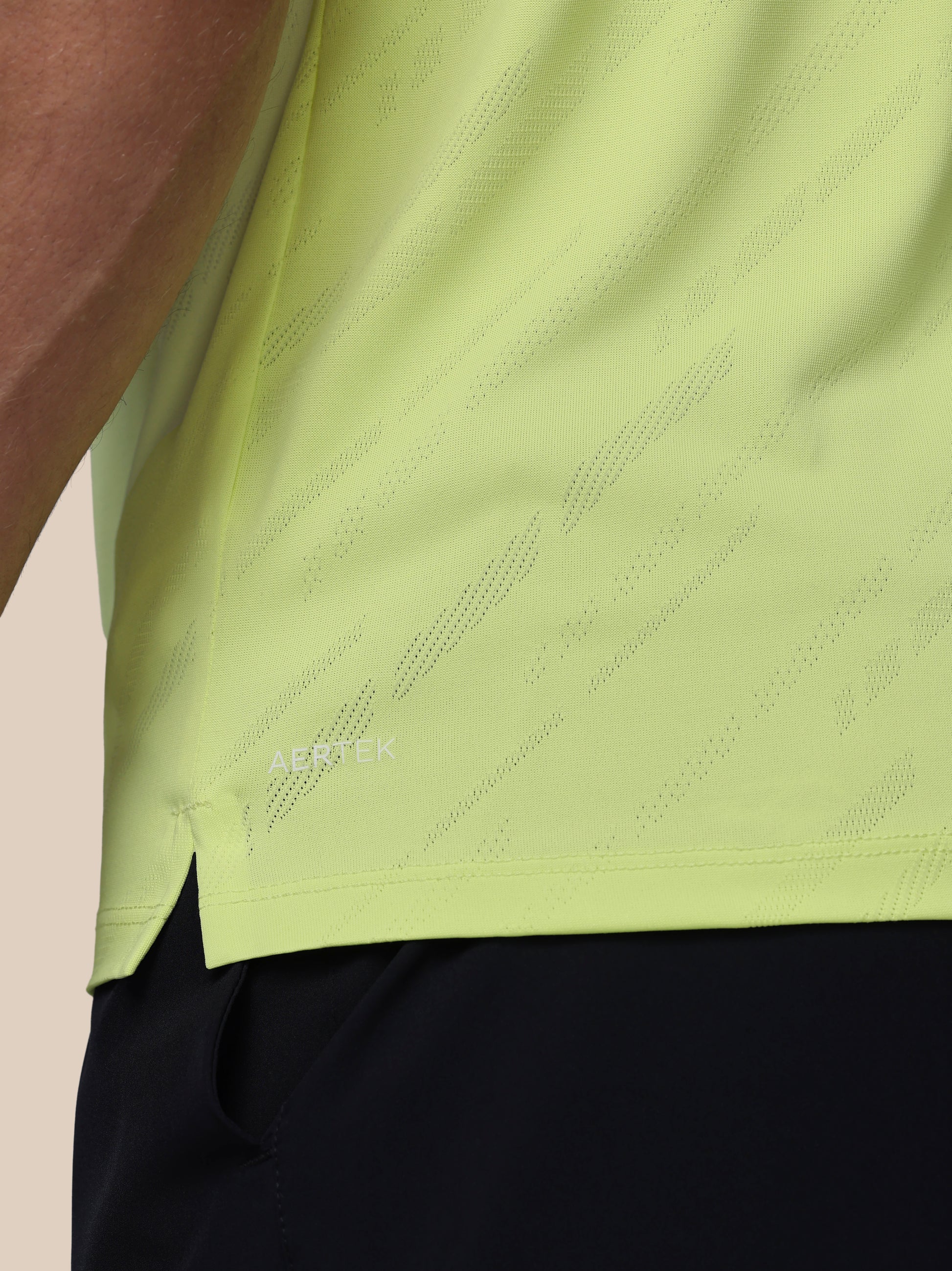 Close-up of a green athletic shirt with Castore logo on a beige background