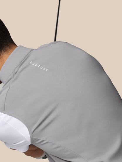 Person wearing a gray hoodie with 'CASTORE' branding on a beige background