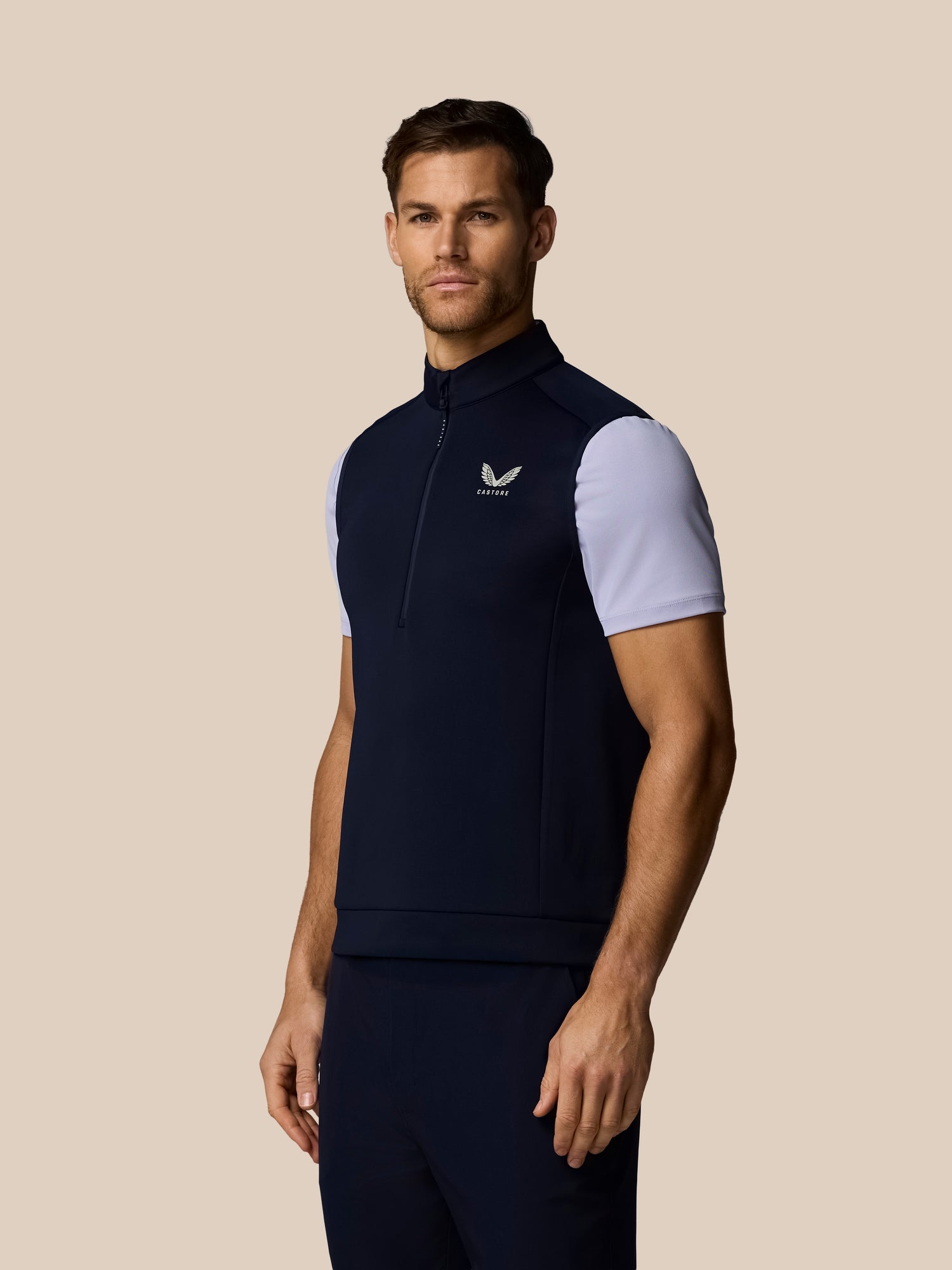 Male model wearing navy Golf Flex Half Zip Gilet with Castore logo on chest
